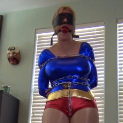 Dee Williams - costume bondage - henchman comes in and gags and blindfolds Dee is chained to a pole - Ultra Girl Unleashed Part 1 of 2